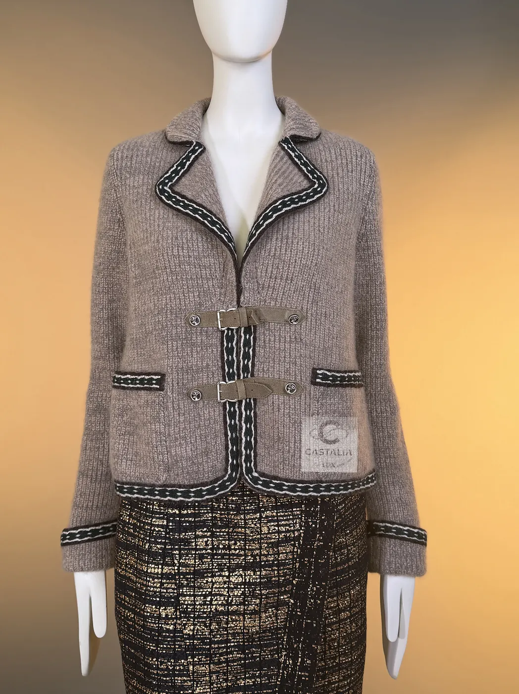 The Paris–Salzburg étoupe cashmere jacket: a braided border in green and ecru, suede straps with buckles