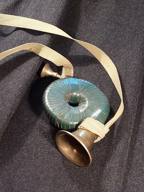 A small brass hunting horn on a dark grey loden coat