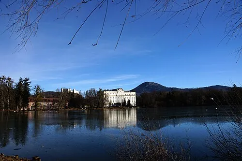 Schloss Leopoldskron, white and pale yellow, reflected in its lake under a winter sky